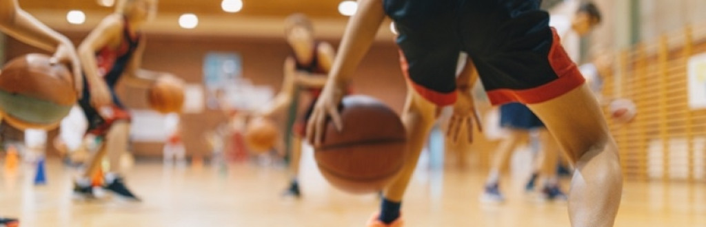 Youth Basketball Team Bouncing Balls on Sports Court