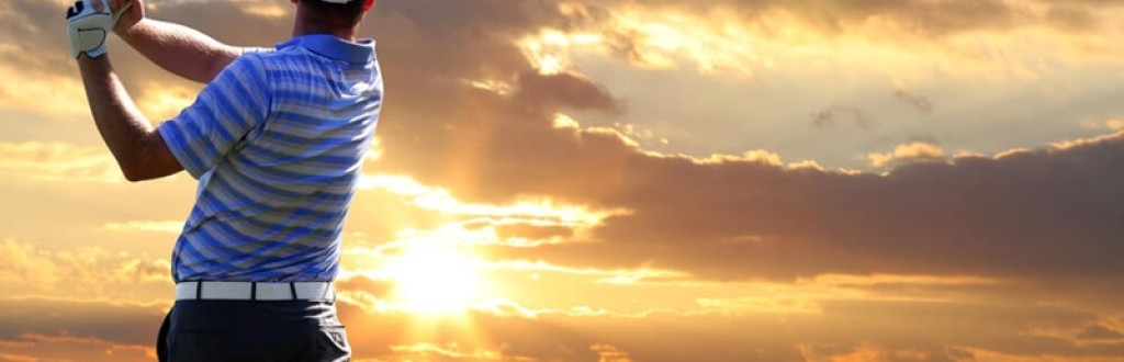 Man playing golf against sunset