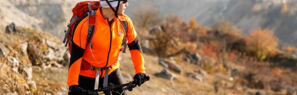 Cyclist-traveler with a backpack on mountain bike