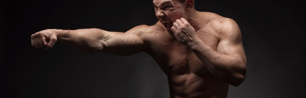 young angry boxer fighting with shadow
