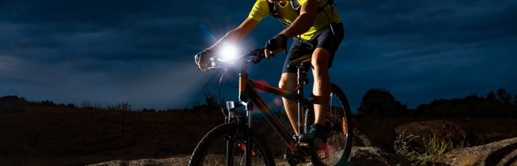 Cyclist Riding the Mountain Bike on the Rocky Trail at Night