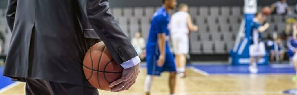 Basketball coach holds the ball in his hand