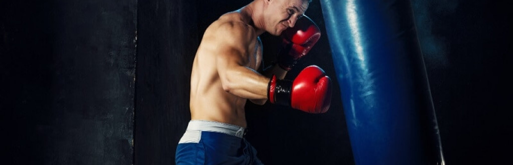 Male boxer training with punching bag