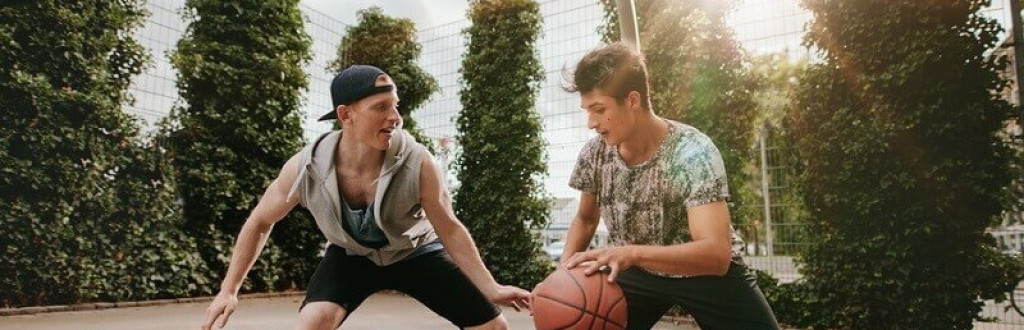 Friends playing basketball against each other and having fun